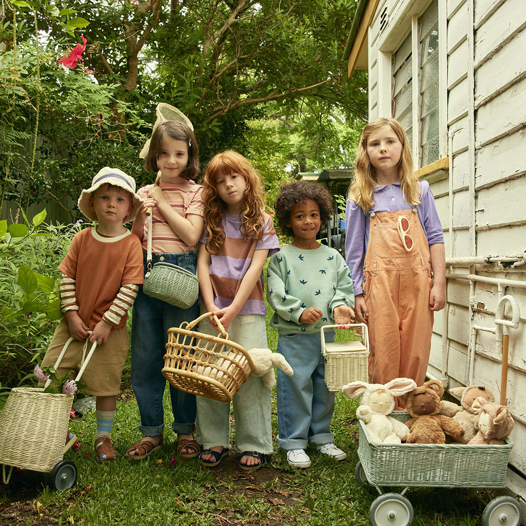 Children holding Olli Ella Baskets and a wagon with Cozy Dinkums.